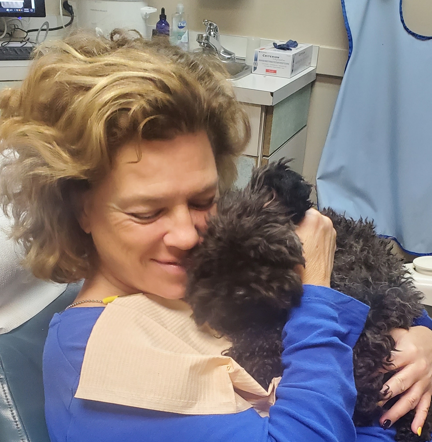 Dental patient being comforted by a dental therapy dog in Erie, PA