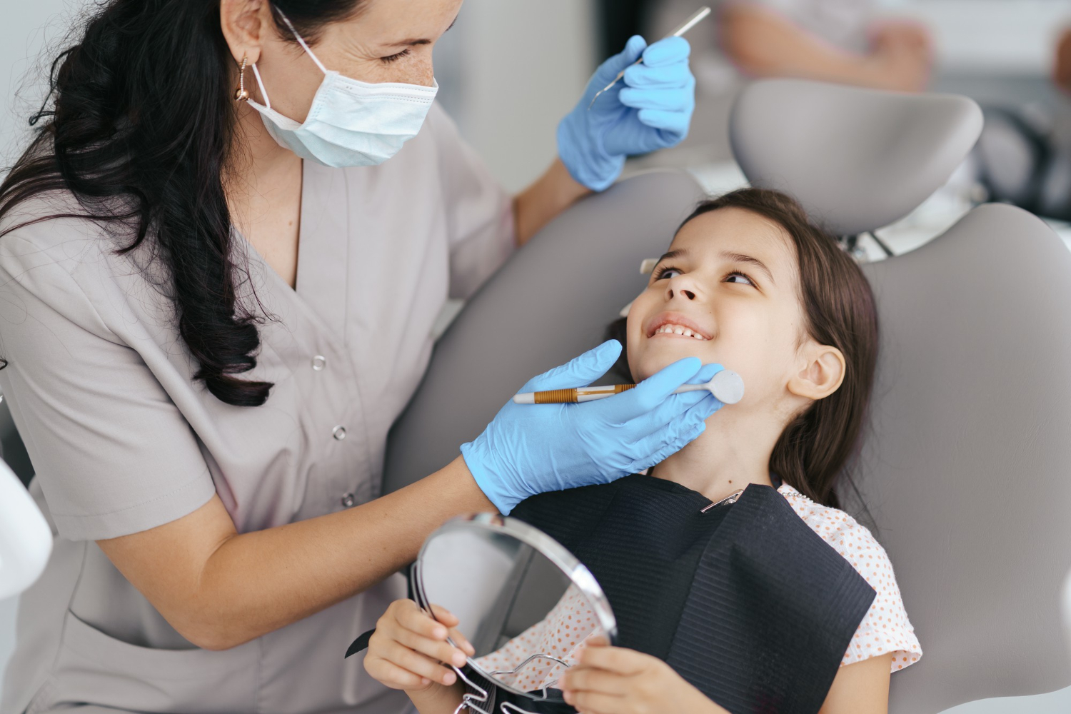 little girl smiling in dental chair with dental assistant dr mahoney sleep dentistry family dentistry