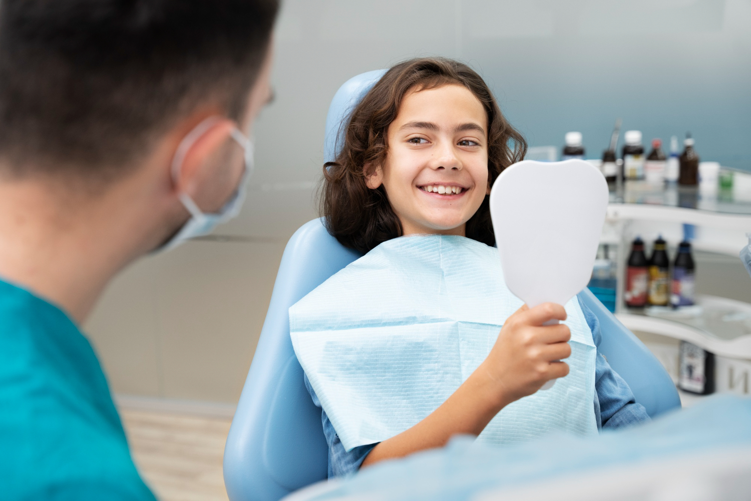 child looking in mirror in dental chair pros and cons of dental sealants sleep dentistry